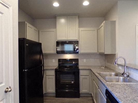 a kitchen with black appliances and white cabinets