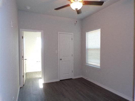 a empty room with a ceiling fan and a door