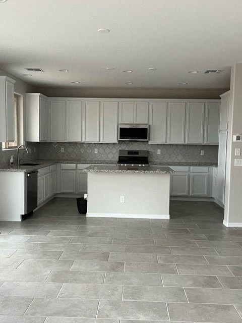 an empty kitchen with white cabinets and a sink