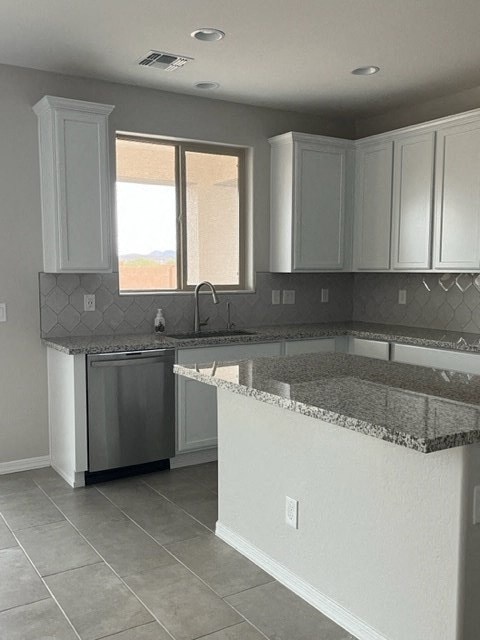an empty kitchen with white cabinets and a counter top