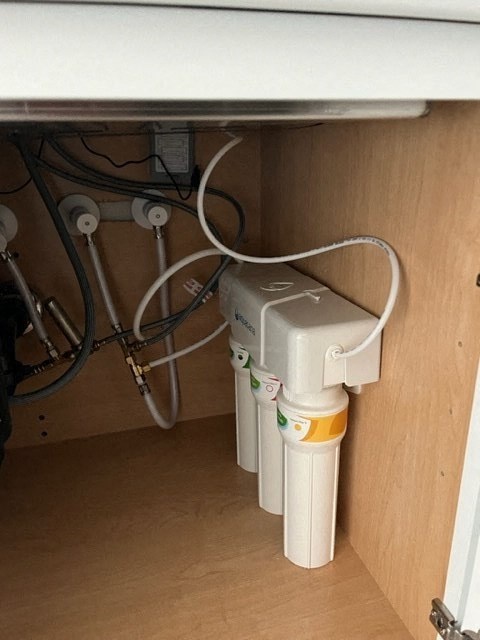 a bunch of wiring under a desk under a table