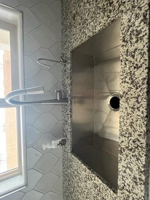 a bathroom with a shower and a granite wall