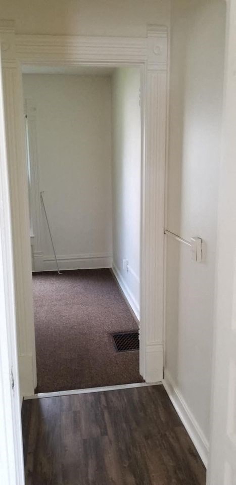a hallway with a door to a room with white walls