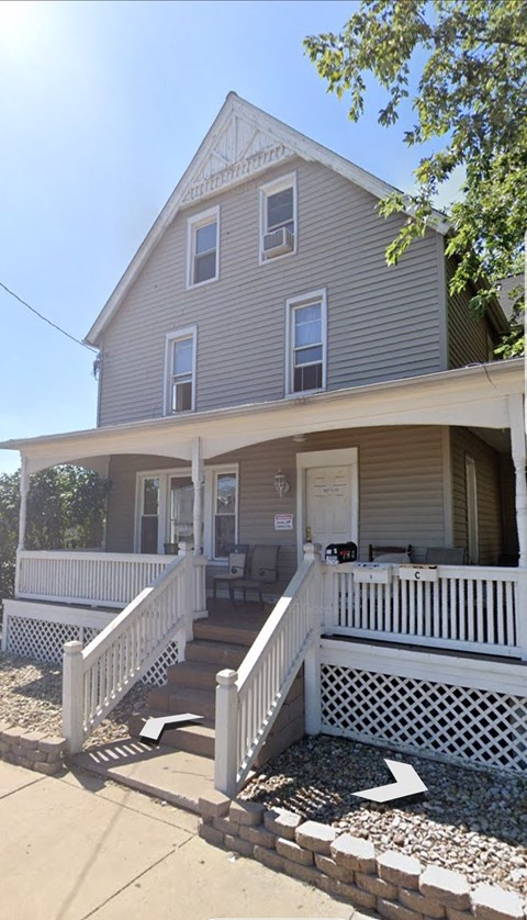 a house with a porch and a white fence