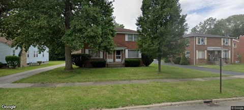 a house on a street with trees in front of it