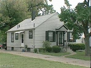 a small white house on the side of a street