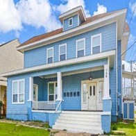 A blue house with white trim and a white door.