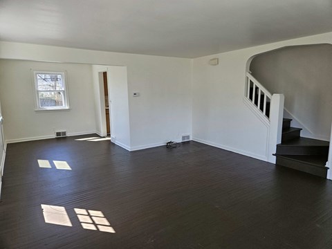 A room with wooden floors and a staircase.