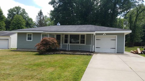 a blue house with a driveway and a white garage door