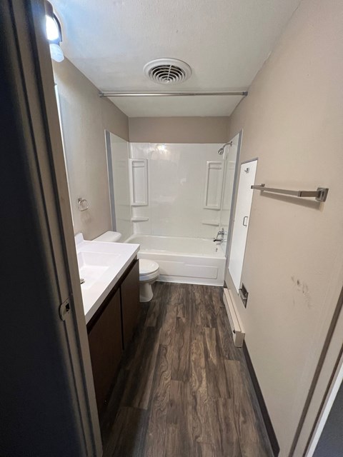 A small bathroom with a toilet, sink, and shower.