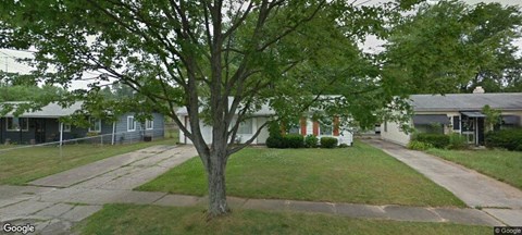 a house with a yard and a tree in front of it