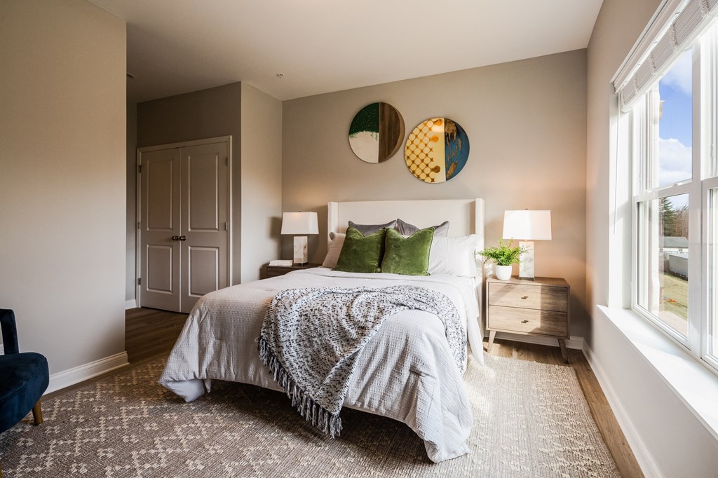 a bedroom with a bed and two windows