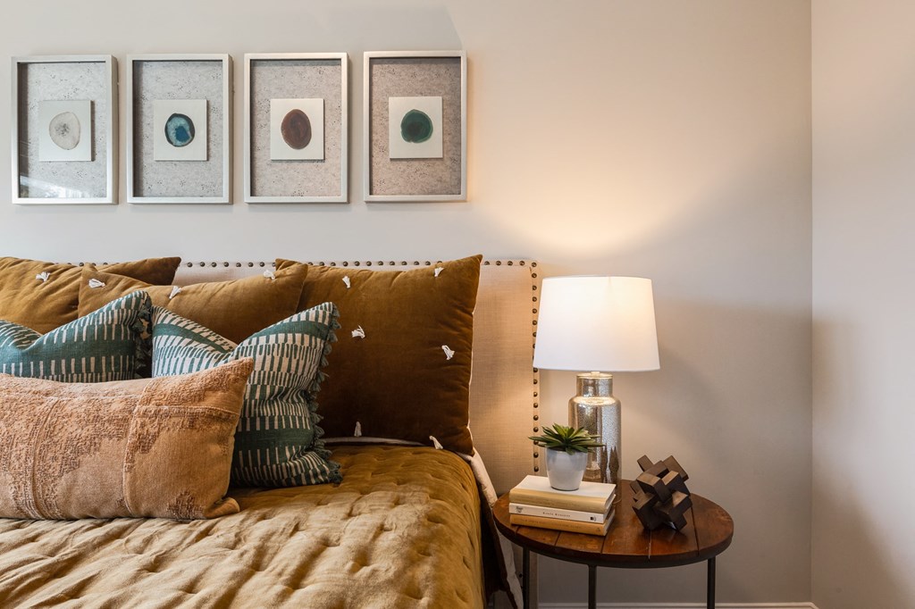 a bedroom with a bed and pillows and pictures on the wall