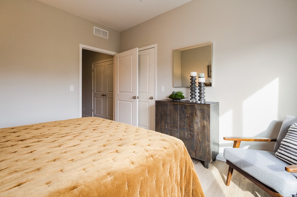 a bedroom with a bed and a dresser and a mirror