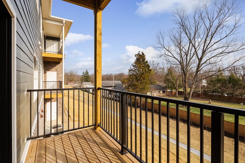 a balcony with a view of a yard and a building