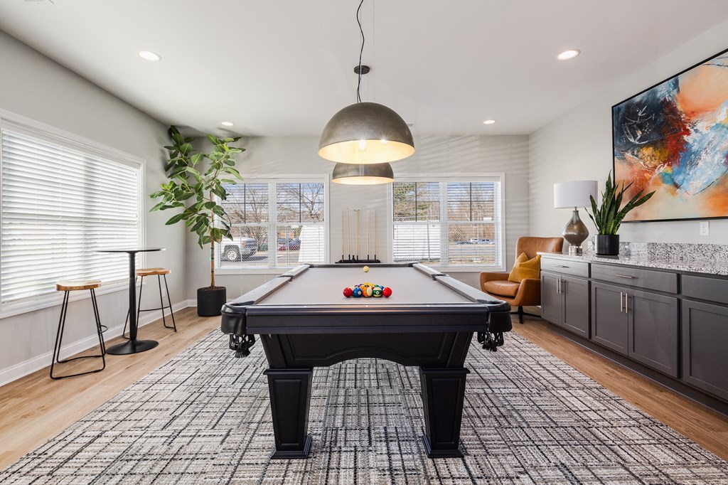 an open living room with a pool table     and a large window