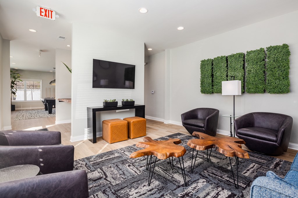 a living room with a tv and chairs and a table