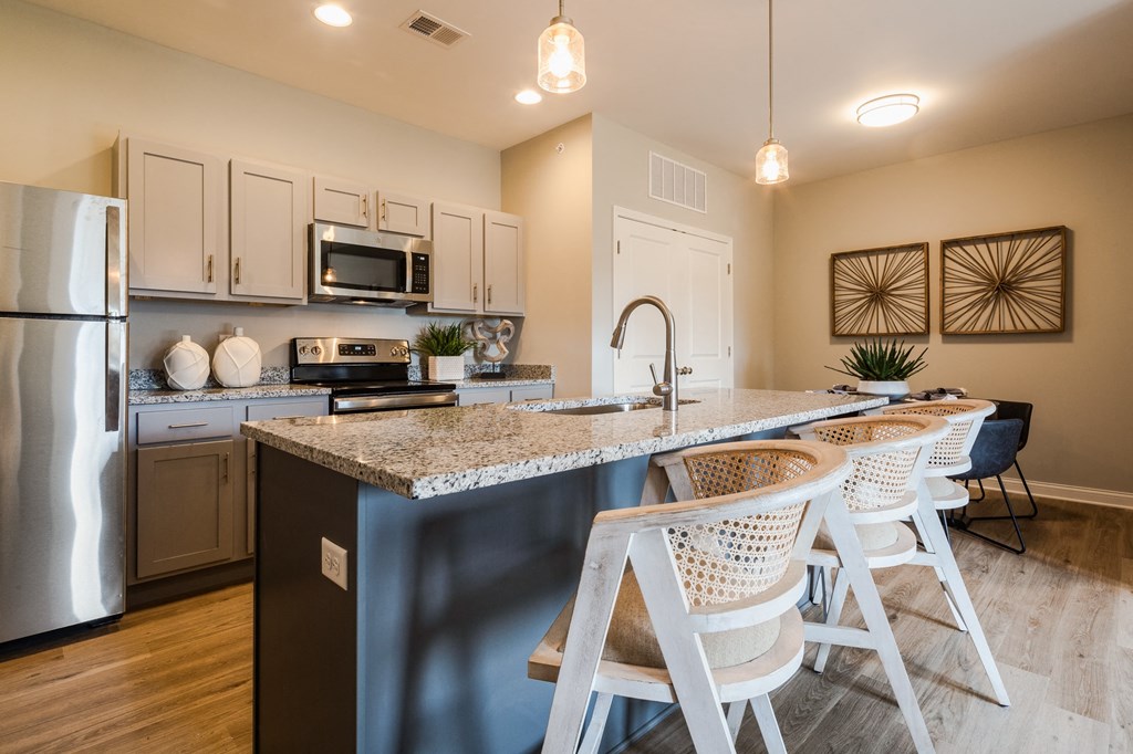 an open kitchen with a marble counter top and bar stools