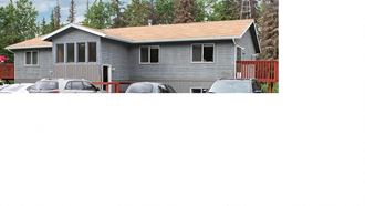 a house with cars parked in a parking lot