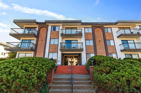 A large building with a red staircase leading to the front door.