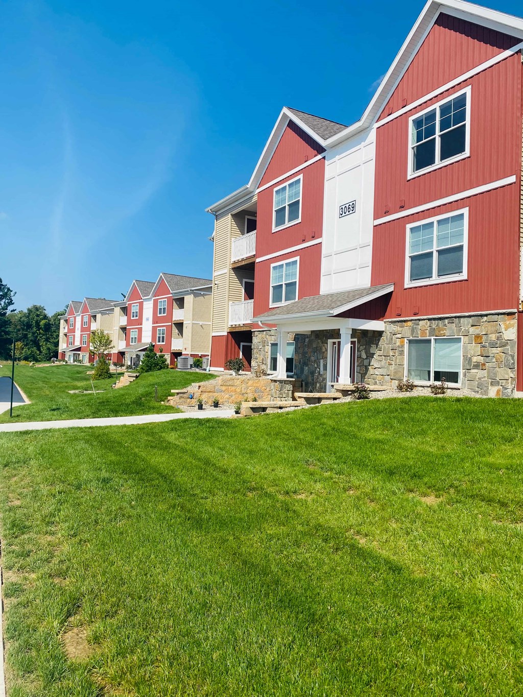 a row of red and white houses on a green lawn