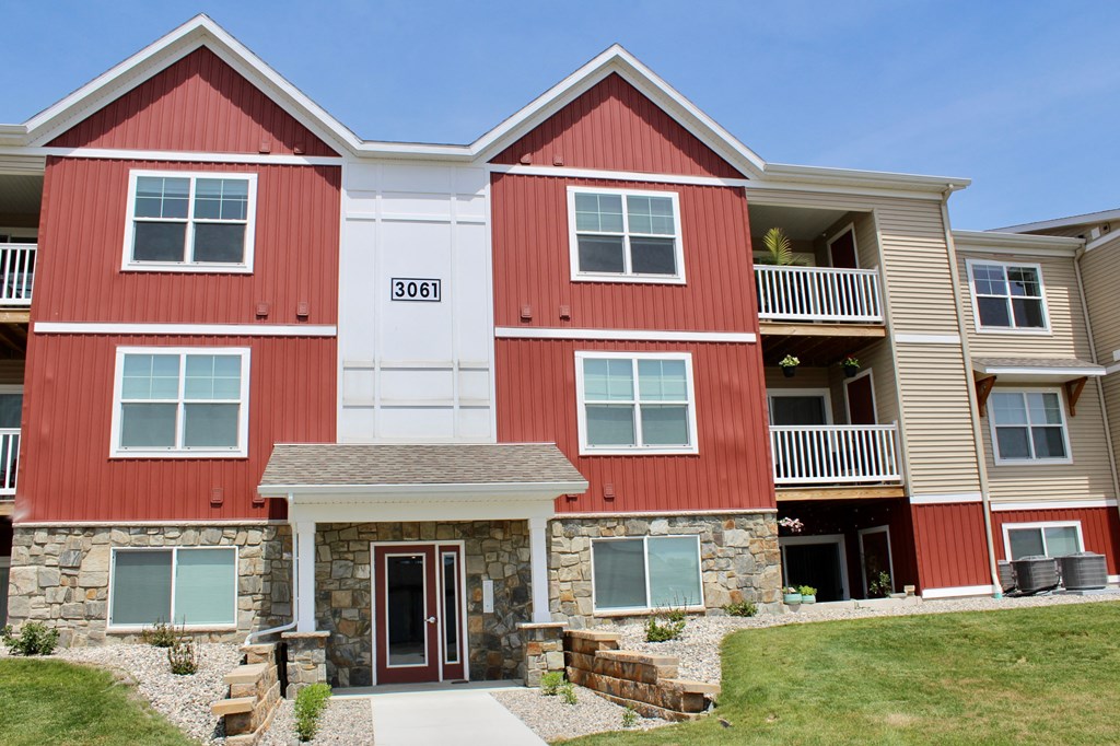 a red and white house with a sidewalk in front of it