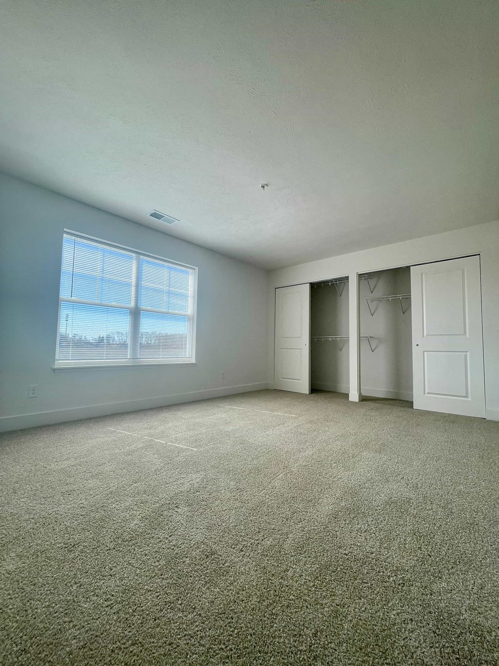 an empty room with carpet and a window