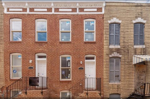 a red brick building with two white doors and windows