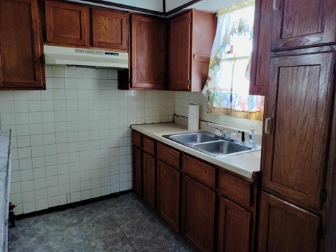 A kitchen with brown cabinets and a white dishwasher.