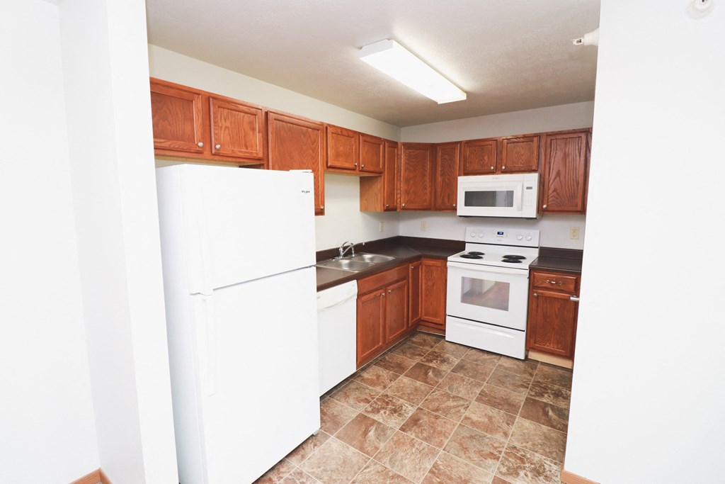 a kitchen with white appliances and wooden cabinets