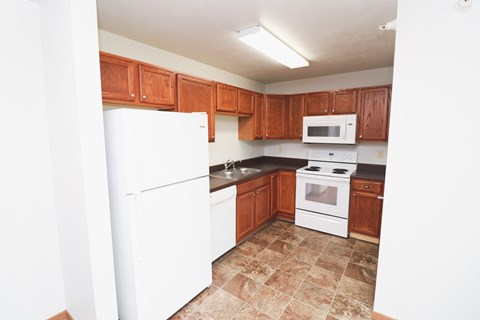 a kitchen with white appliances and wooden cabinets
