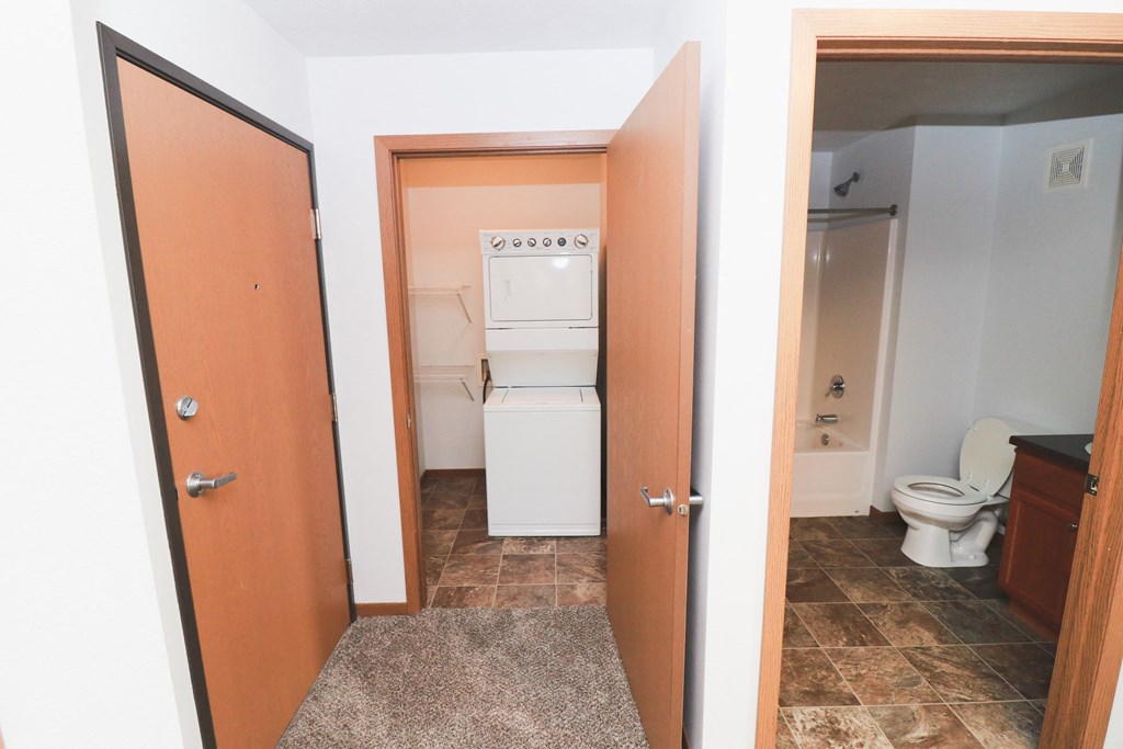 a bathroom with a washer and dryer closet and a toilet and a bathroom
