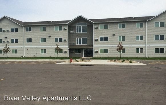 an apartment building with a fire hydrant in a parking lot