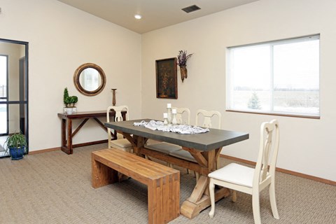 a dining room with a table and chairs and a window
