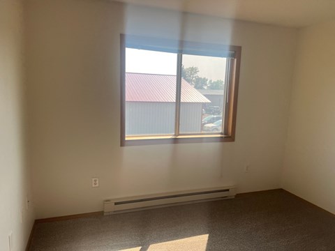 A room with a window and a radiator on the floor.