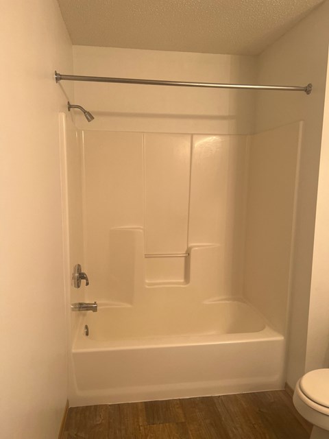 A white bathroom with a toilet and a bathtub.