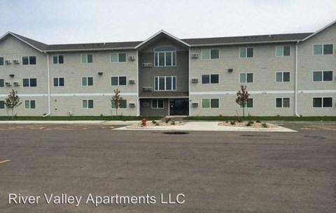an apartment building with a fire hydrant in a parking lot