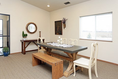 a dining room with a table and chairs and a window