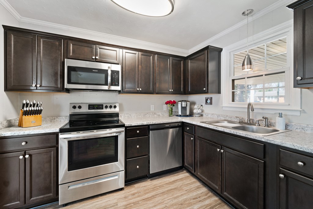 a kitchen with dark wood cabinets and stainless steel appliances