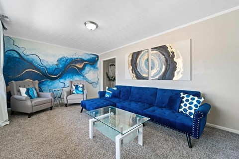 a living room with a blue couch and a glass coffee table
