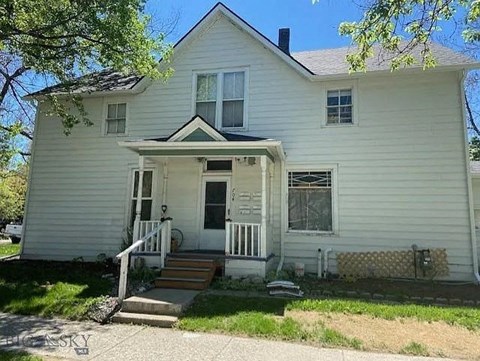 a white house with a front porch and steps
