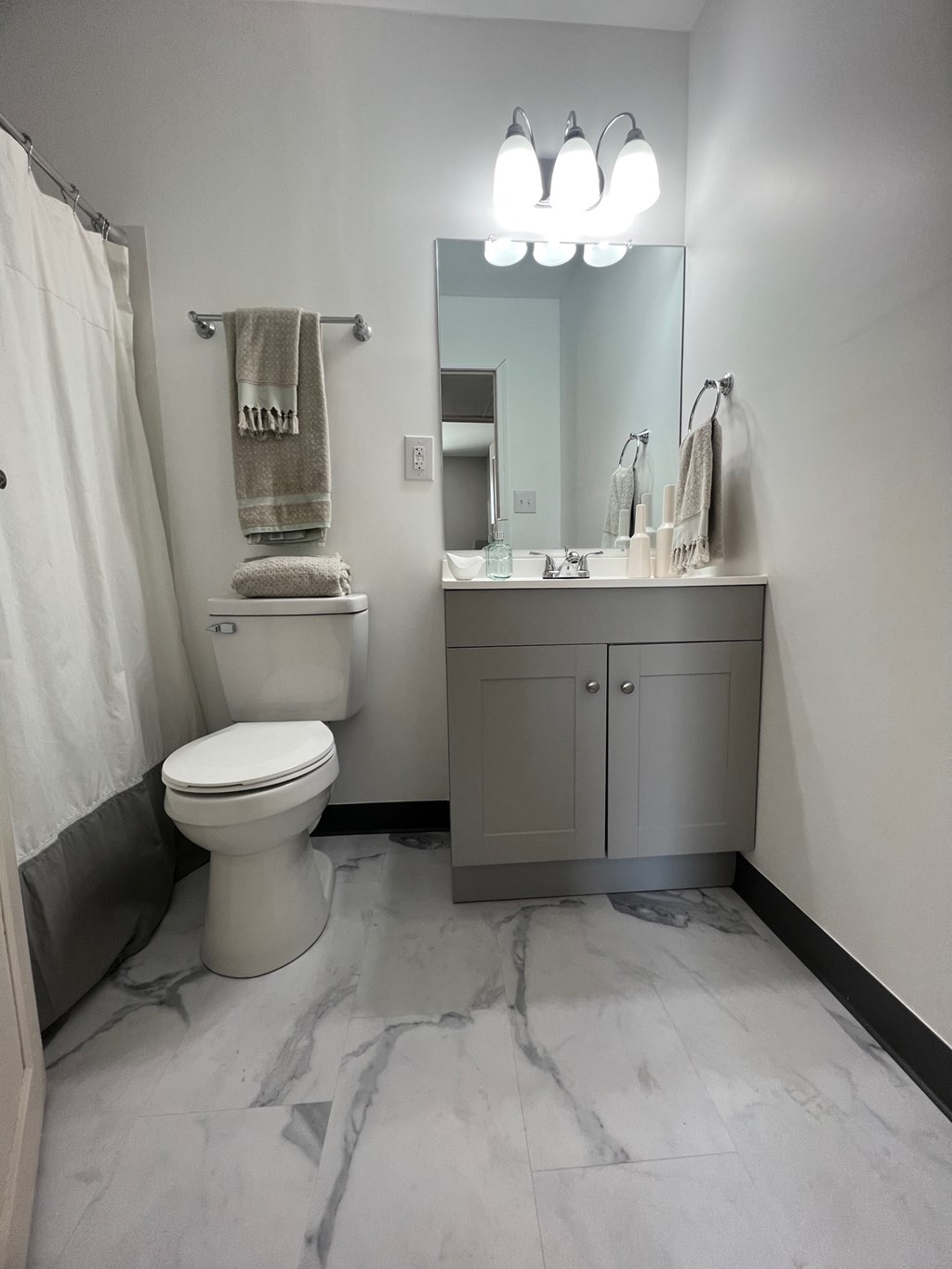 a bathroom with a toilet and a sink and a mirror