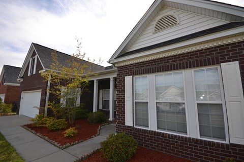 the front of a brick house with a sidewalk