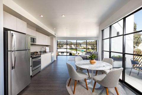 a kitchen with stainless steel appliances and a table and chairs