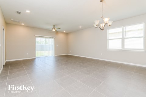 A spacious room with a chandelier and a ceiling fan.