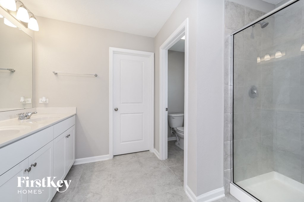 a bathroom with a shower and a sink and a toilet