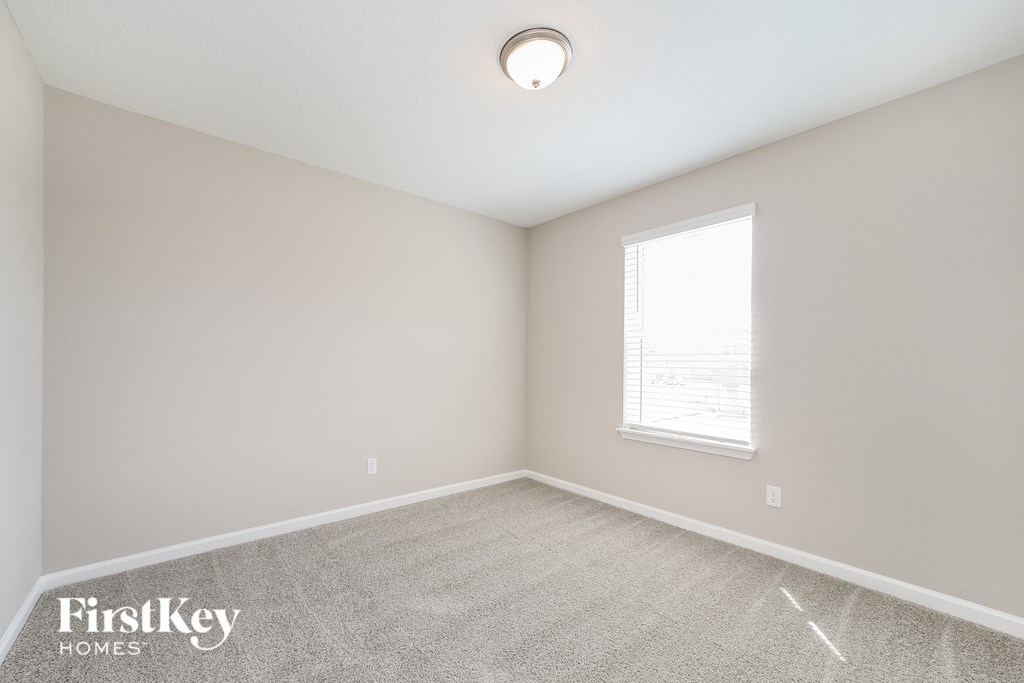 an empty room with a window and a carpet