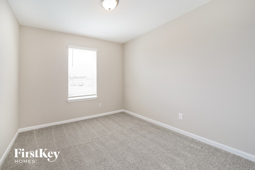 a bedroom with a carpeted floor and a window