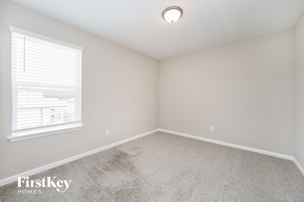a bedroom with a carpeted floor and a window