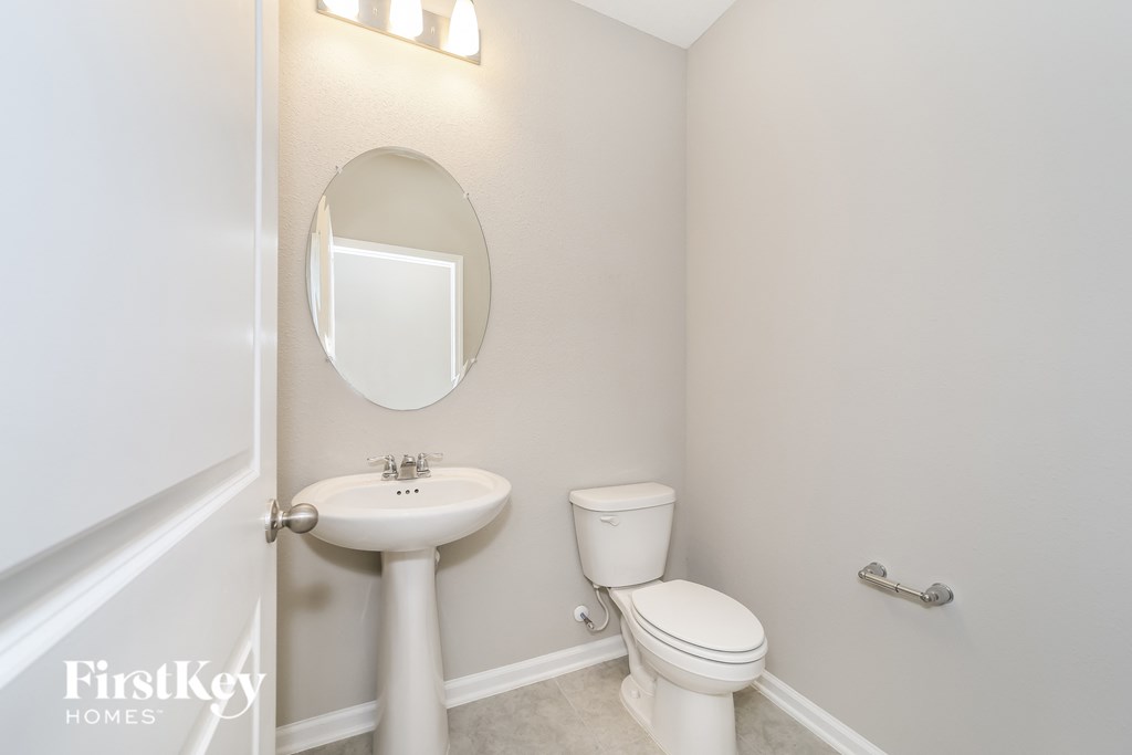 a small bathroom with a toilet and a sink and a mirror